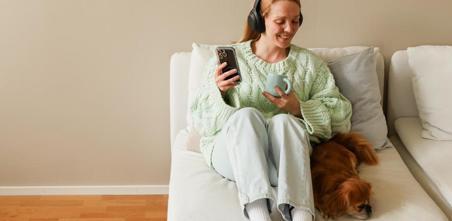 nainen kuuntelee äänikirjaa sohvalla