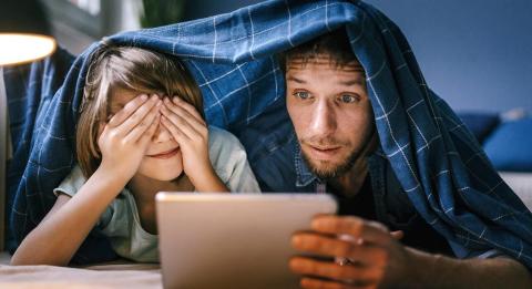 Isä ja poika katselee pädiä