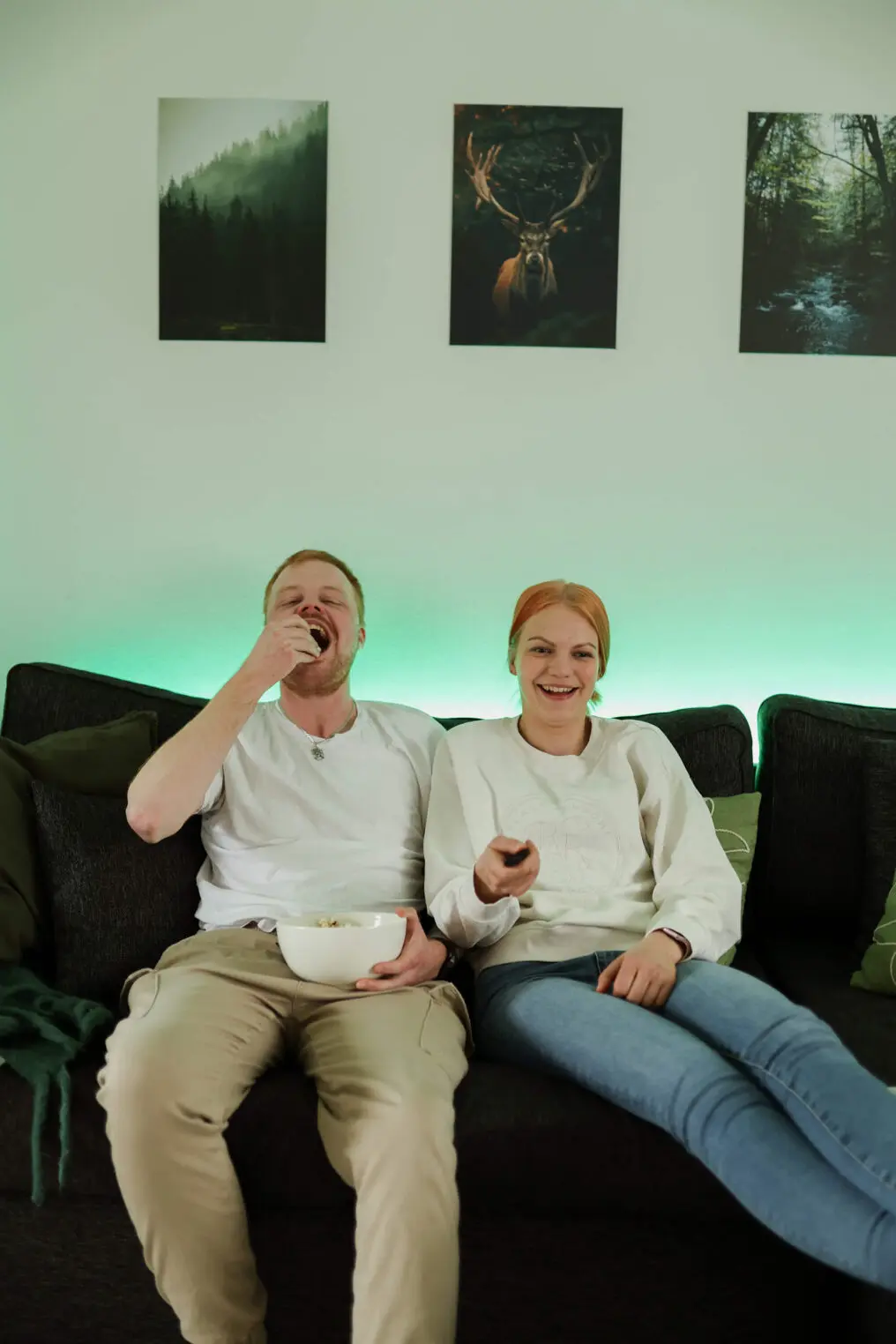 mies ja nainen sohvalla syömässä popcornia